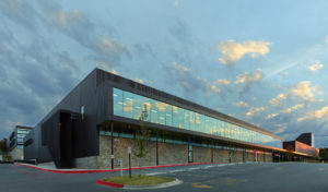 Exterior shot of the glass window walls and metal structure seen at sundown