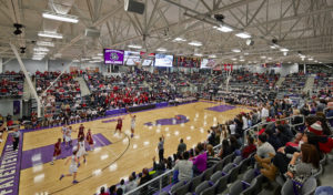 Interior of the basketball stadium space during a heated basketball game with a full crowd