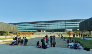 Children relaxing in the courtyard below the repeating glass windows of the library