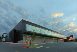 Exterior shot of the glass window walls and metal structure seen at sundown