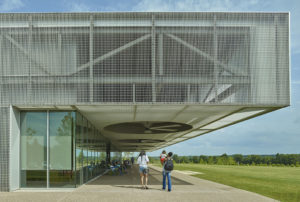 A view of the aluminum bar grate wrapping the edges of the exterior as patrons relax in the shade