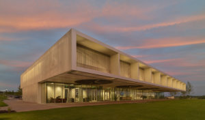 Shelby Farms Park Visitor Center seen at sunset featuring a large overhanging 'front porch' overlooking fresh-cut grass