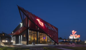 Drive-through line passes next to the metal red and gray exterior of the restaurant