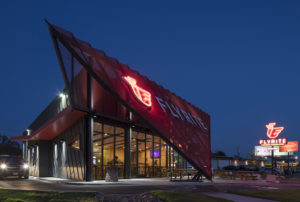 Drive-through line passes next to the metal red and gray exterior of the restaurant