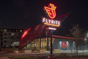 Flyrite neon sign shot at night next to the metal screen shade and restaurant structure
