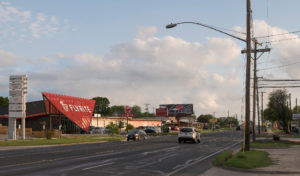 The Flyrite building's bold design and red expressive expanded metal screen seen from the Austin, Texas streets