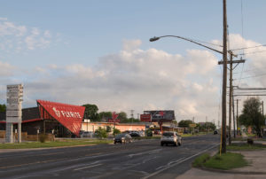 The Flyrite building's bold design and red expressive expanded metal screen seen from the Austin, Texas streets