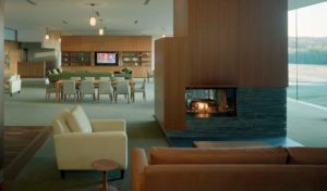 The lounge area with lit fireplace surrounded by modern couches and chairs
