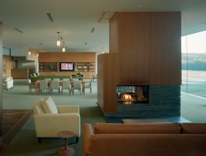 The lounge area with lit fireplace surrounded by modern couches and chairs