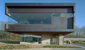 Metal and stone face of the Clubhouse meets the landscaping of plants and pine needles