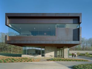 Metal and stone face of the Clubhouse meets the landscaping of plants and pine needles