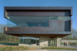 Metal and stone face of the Clubhouse meets the landscaping of plants and pine needles