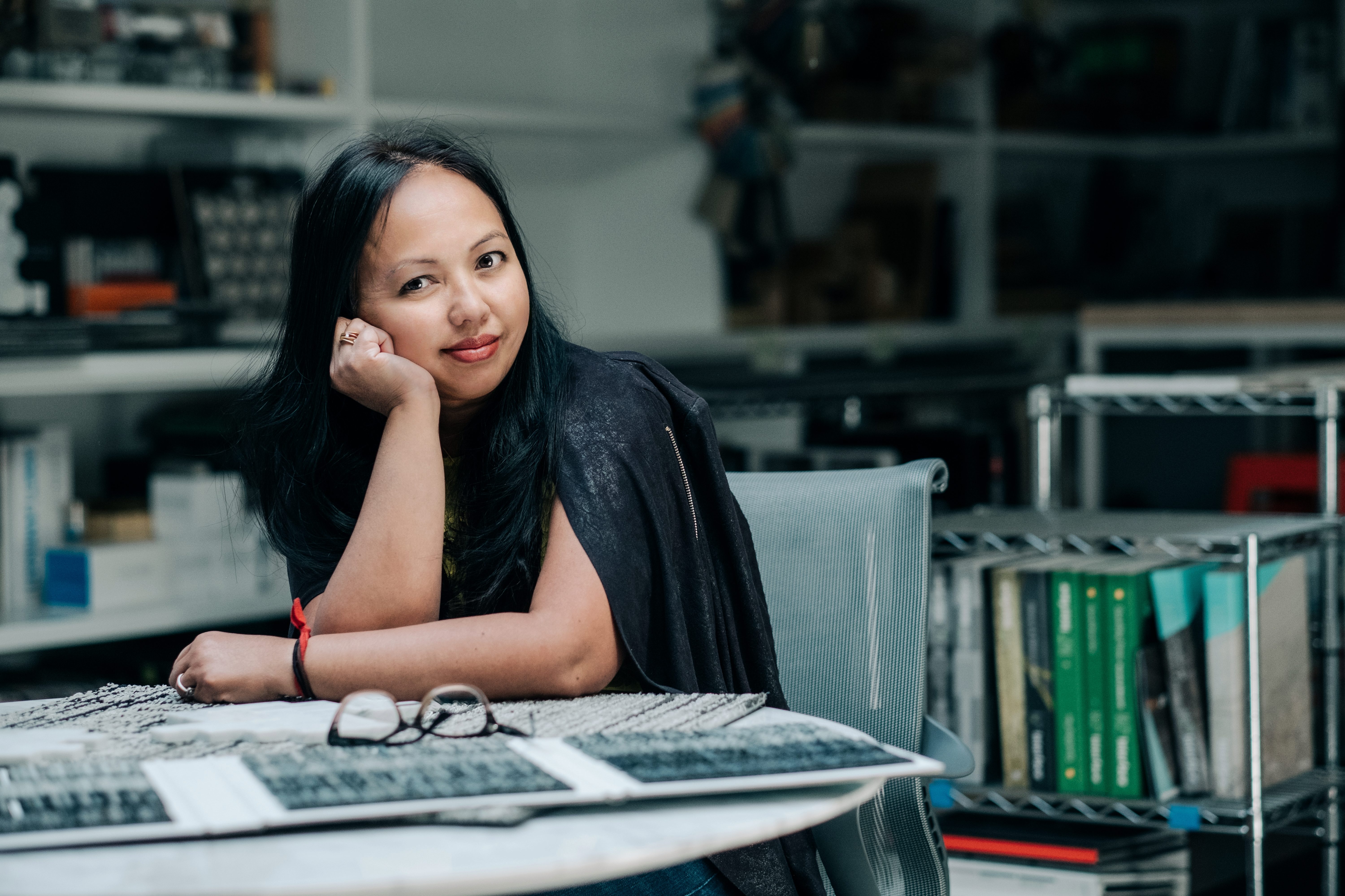 Meryati Johari Blackwell in her office workspace reviewing material samples at a desk