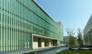 A sprawling shot of fritted glass walls and limestone along the exterior of the Design Center