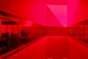 Tinted red glass from the oculus looks though to a classroom of students