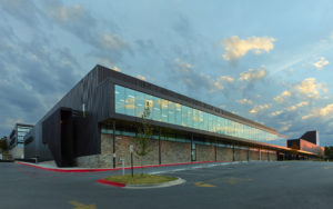 Exterior shot of the glass window walls and metal structure seen at sundown