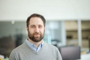 MBA team member headshot featuring Kertis Weatherby with short brown hair and beard wearing a light gray sweater