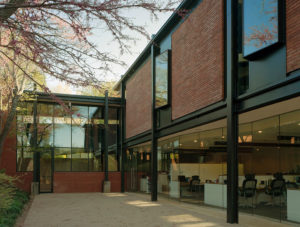 The Fulbright Building courtyard space with trees and shrubs intersecting with the brick and steel building