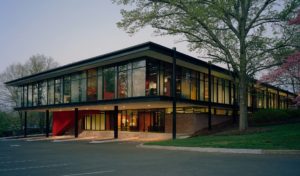 The Fulbright Building's glass windows illuminated from inside at dusk