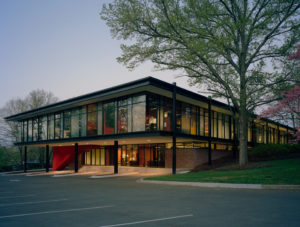 The Fulbright Building's glass windows illuminated from inside at dusk