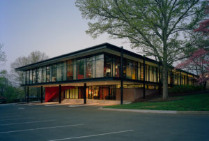 The Fulbright Building's glass windows illuminated from inside at dusk