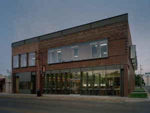 A stark view of the building's exterior facing Main St. at dusk