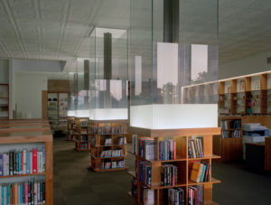 Wooden shelves and glass surround the building's interior support pillars