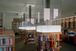 Wooden shelves and glass surround the building's interior support pillars