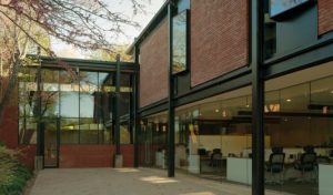 The Fulbright Building courtyard space with trees and shrubs intersecting with the brick and steel building