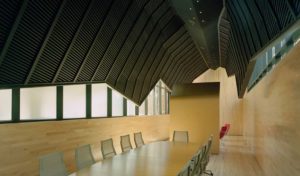 The Fulbright Building shroud hanging above a wooden floored and walled conference room