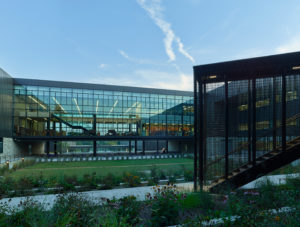 Fayetteville High School courtyard space with metal and glass materials landscaped with grass and flowers