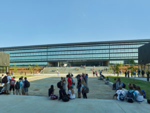 Children relaxing in the courtyard below the repeating glass windows of the library