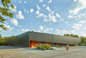 View of the metal cladding carapace hanging over the cypress siding