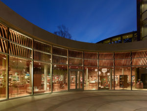 Crystal Bridges Museum Store exterior seen at night while being well-lit through large glass windows