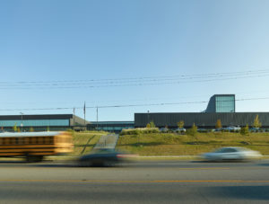 The building's new cohesive exterior face seen from MLK boulevard to the south amidst busy traffic from cars and busses