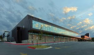 Exterior shot of the glass window walls and metal structure seen at sundown