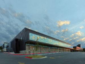 Exterior shot of the glass window walls and metal structure seen at sundown