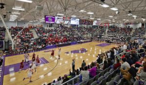 Interior of the basketball stadium space during a heated basketball game with a full crowd