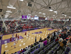 Interior of the basketball stadium space during a heated basketball game with a full crowd