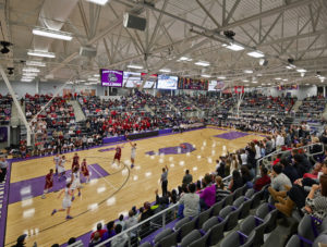 Interior of the basketball stadium space during a heated basketball game with a full crowd