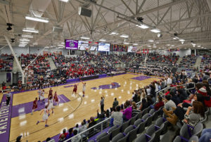 Interior of the basketball stadium space during a heated basketball game with a full crowd