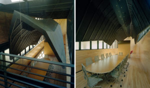 Wooden interior redesign of The Fullbright Building interior showcasing a ‘shroud,’ clad in black zinc, suspended above a wooden conference room