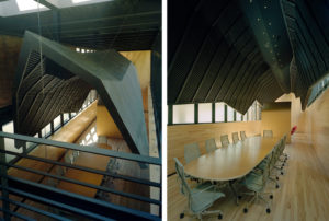 Wooden interior redesign of The Fullbright Building interior showcasing a ‘shroud,’ clad in black zinc, suspended above a wooden conference room