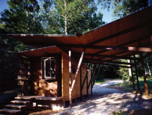 Wooden roof covers the porch and parking spot