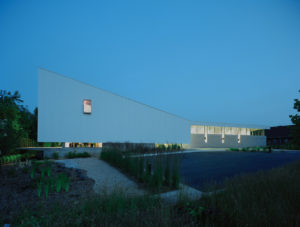 A view of the buildings beautiful white exoskeleton and night with lights shining from inside