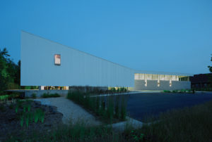 A view of the buildings beautiful white exoskeleton and night with lights shining from inside