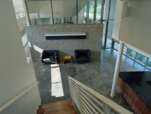 The Srygley Office Building interior showing concrete blocks and bright white walls above polish concrete floors decorated with modern office furniture