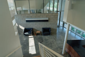 The Srygley Office Building interior showing concrete blocks and bright white walls above polish concrete floors decorated with modern office furniture