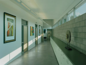 The Srygley Office Building hallway with concrete blocks opposing white walls with hanging artwork