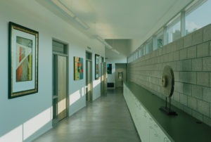 The Srygley Office Building hallway with concrete blocks opposing white walls with hanging artwork